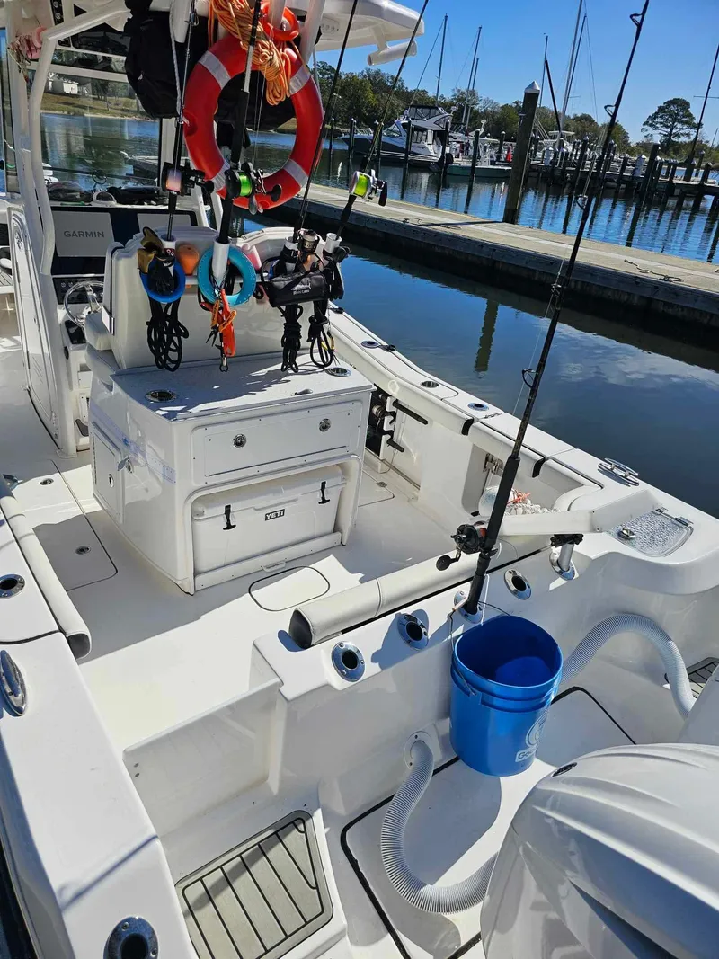 Slide: The Image of 2025 Tidewater 272 CC Adventure boat docked, featuring fishing gear and equipment. - 4