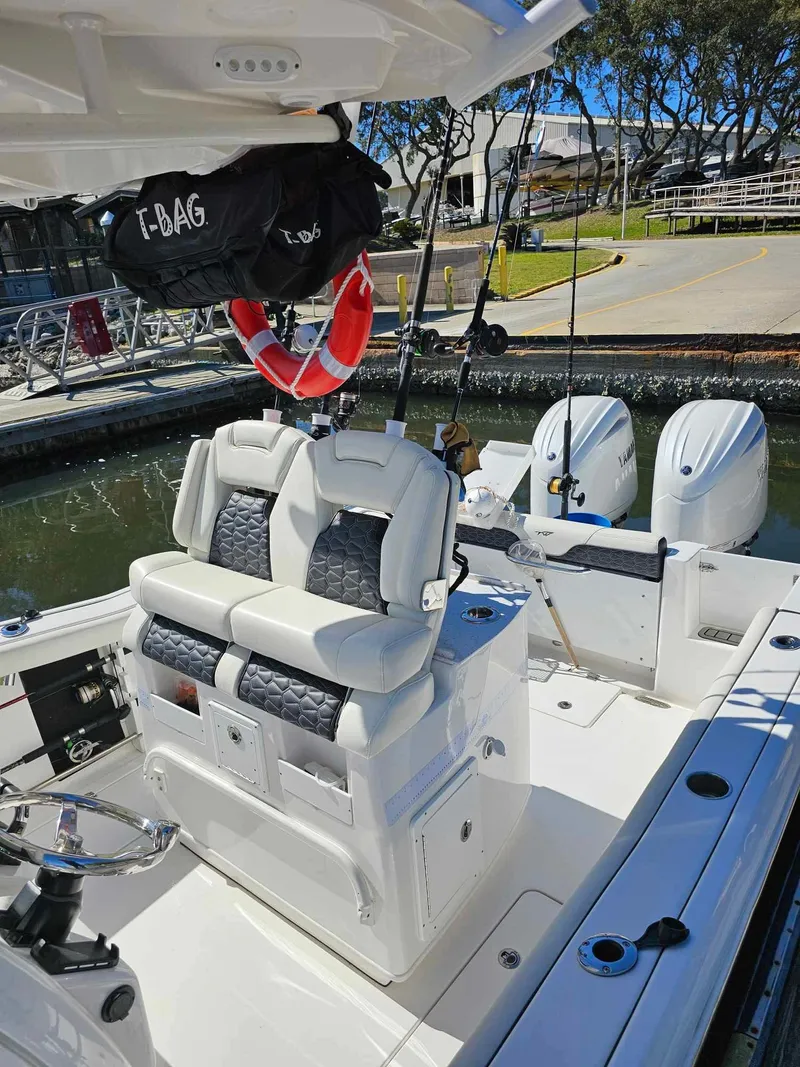Slide: The Image of 2025 Tidewater 272 CC Adventure boat with dual engines and cushioned seating at a marina. - 6