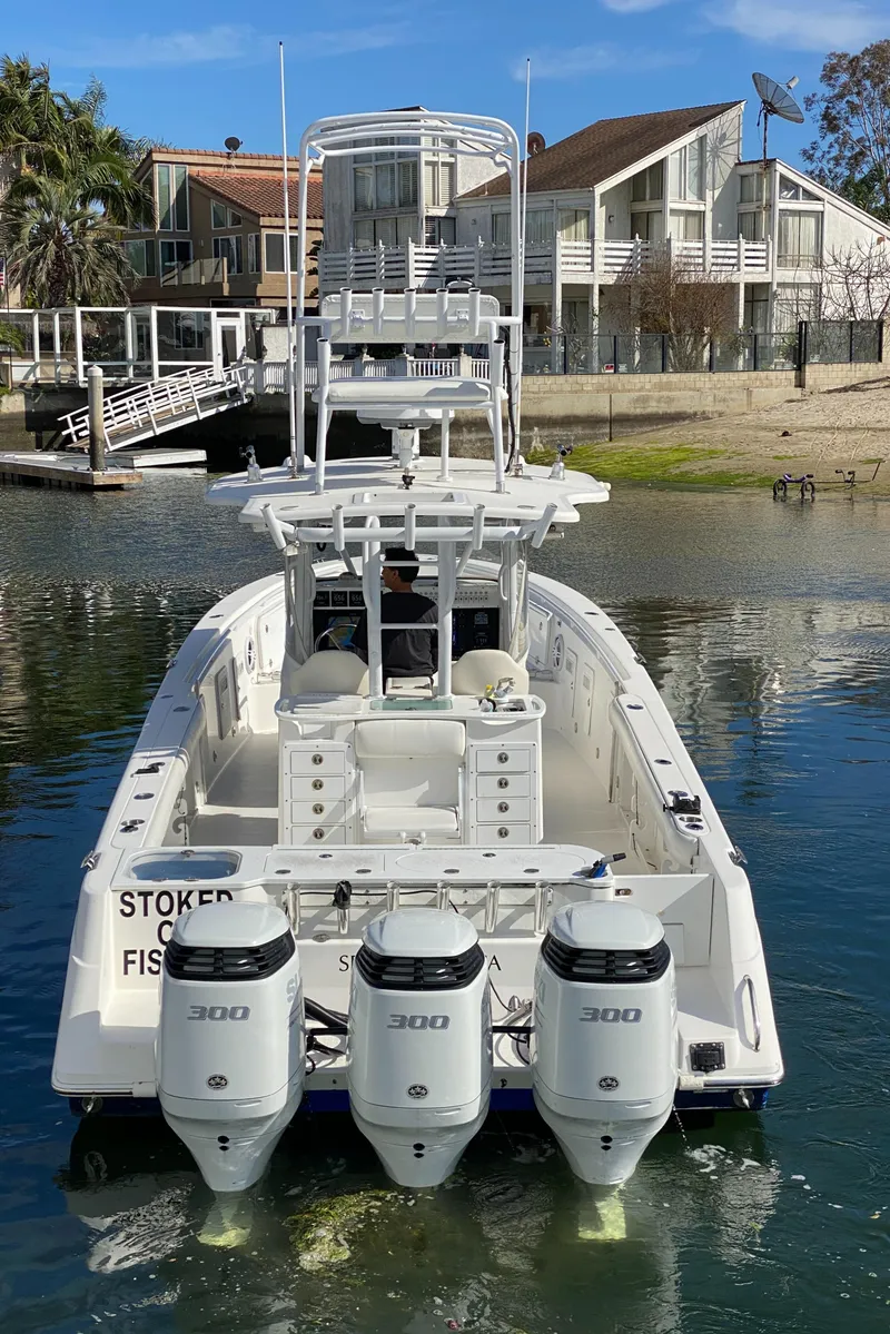 Slide: The Image of 2008 Everglades 355 Center Console boat with triple 300 HP engines docked near waterfront homes. - 17
