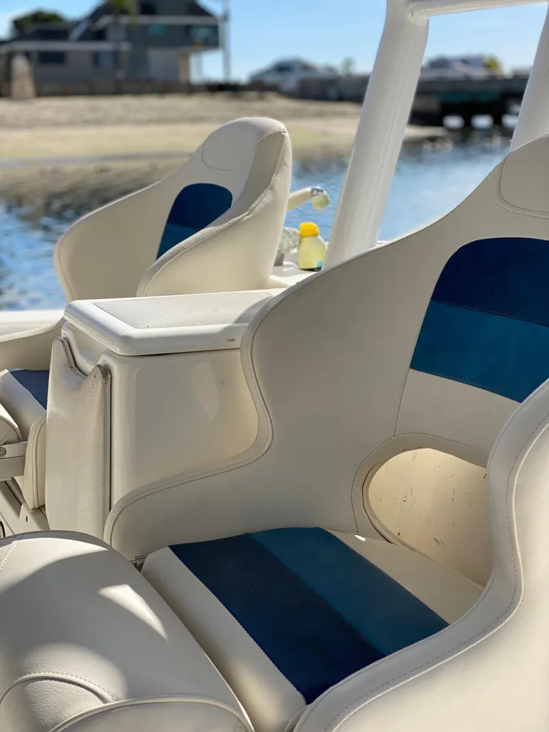 Slide: The Image of 2008 Everglades 355 Center Console boat seats with blue accents, docked by the water. - 18