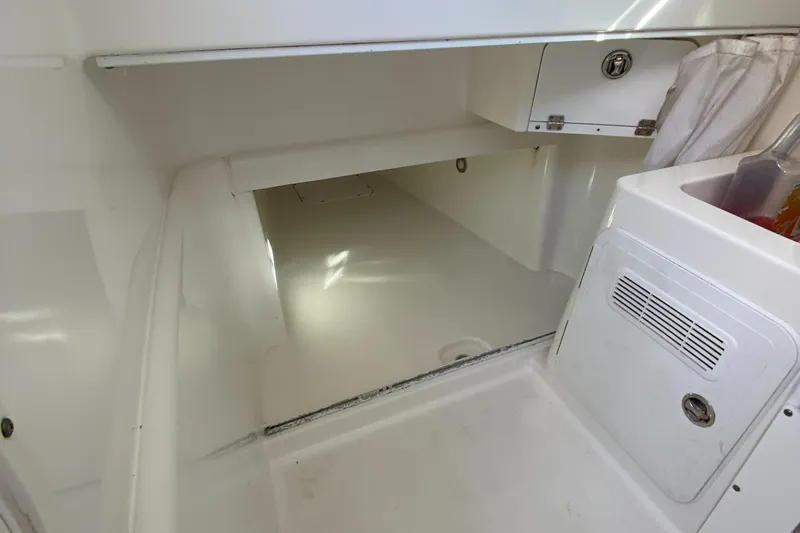 Slide: The Image of Interior cabin of 2008 Everglades 355 Center Console boat, featuring storage and white finish. - 21