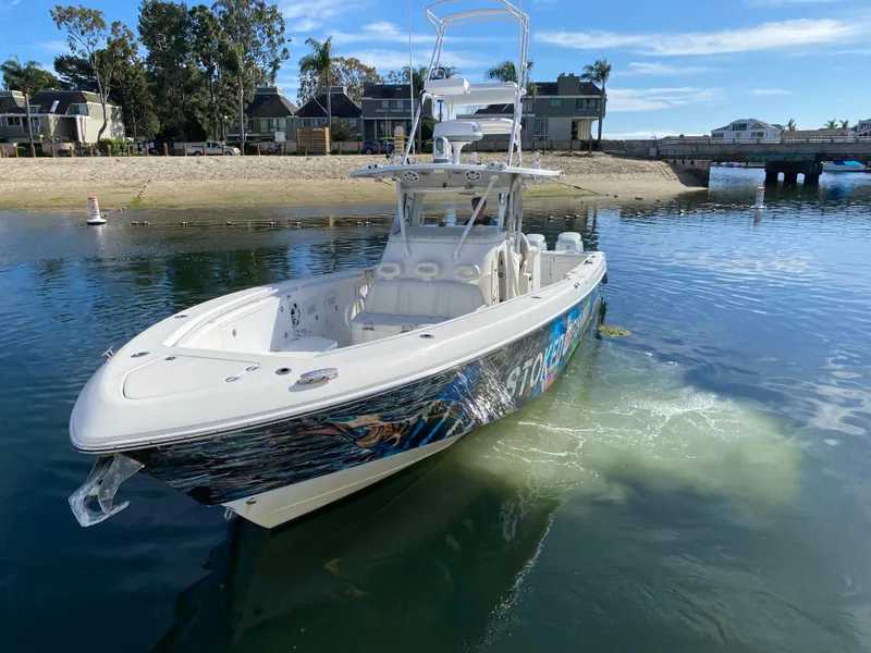 Slide: The Image of 2008 Everglades 355 Center Console boat on calm water near a sandy shore. - 5