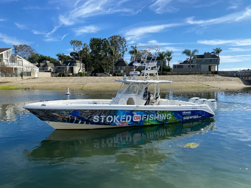 Slide: The Image of 2008 Everglades 355 Center Console boat on water, vibrant "Stoked on Fishing" design. - 8