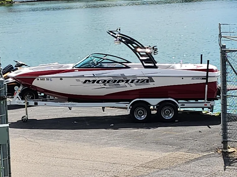 Slide: The Image of 2013 Moomba Mojo 2.5 boat on trailer by the water. - 0