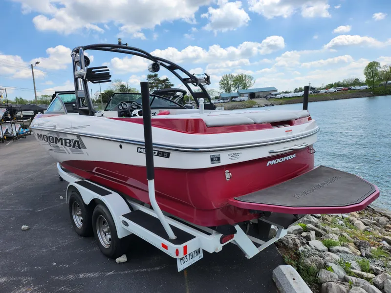 Slide: The Image of 2013 Moomba Mojo 2.5 boat on trailer by a lake under a cloudy sky. - 1