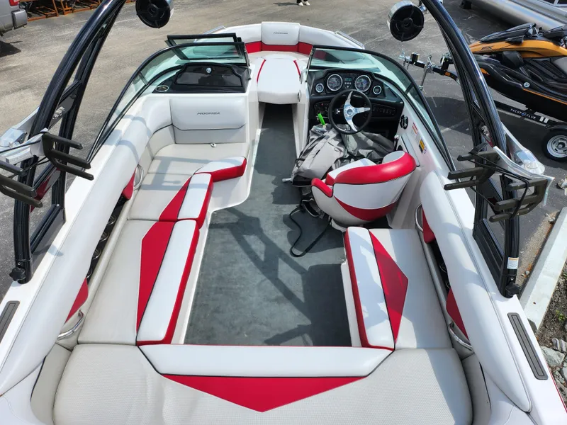Slide: The Image of 2013 Moomba Mojo 2.5 boat interior with red and white seating, steering wheel, and dashboard. - 12