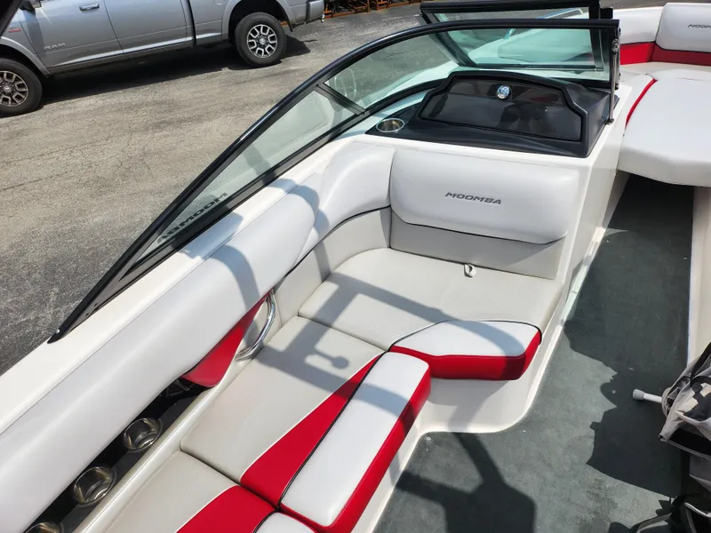 Slide: The Image of 2013 Moomba Mojo 2.5 boat interior with white and red seating, parked outdoors. - 13