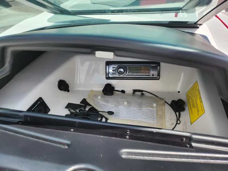 Slide: The Image of 2013 Moomba Mojo 2.5 boat dashboard with stereo system and storage compartment. - 19