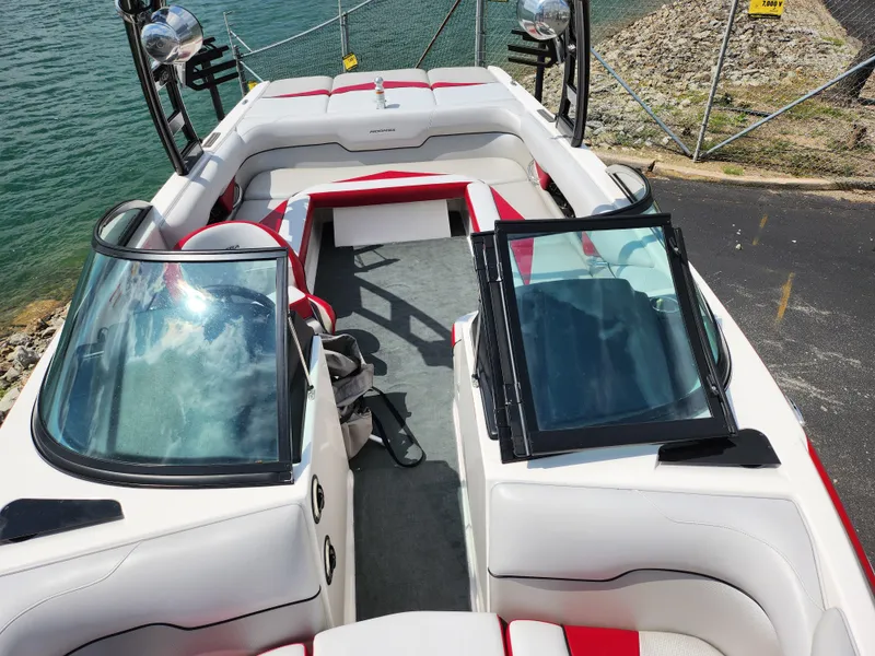 Slide: The Image of 2013 Moomba Mojo 2.5 boat interior with red and white seating, docked by the water. - 23