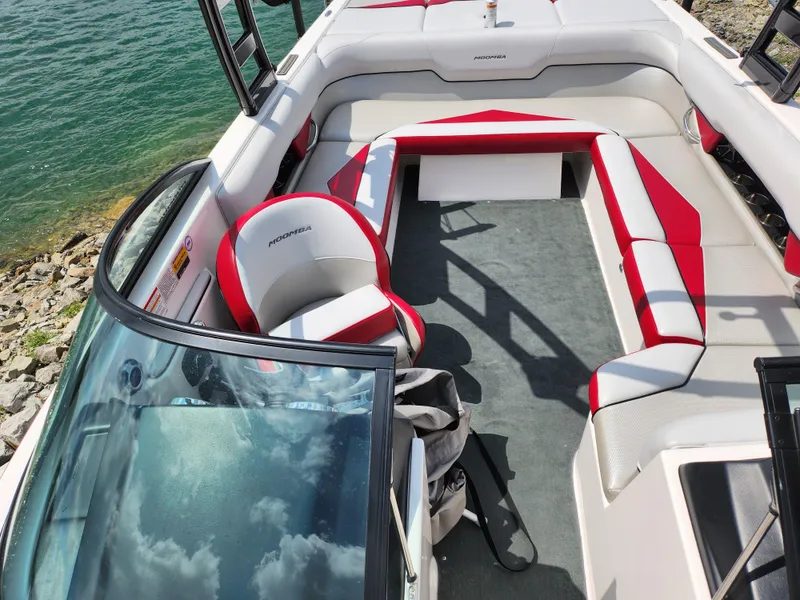 Slide: The Image of 2013 Moomba Mojo 2.5 boat interior with red and white seating near water. - 24