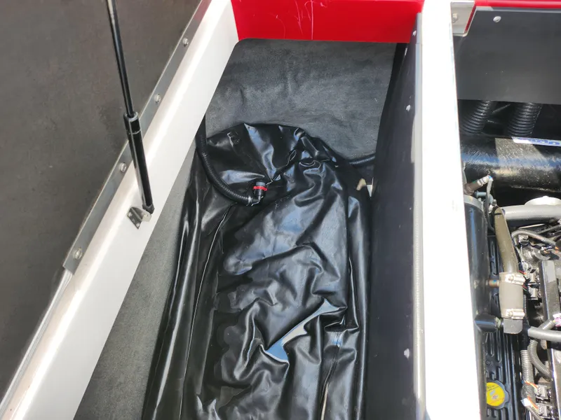 Slide: The Image of 2013 Moomba Mojo 2.5 boat storage compartment with black cover and visible engine components. - 29