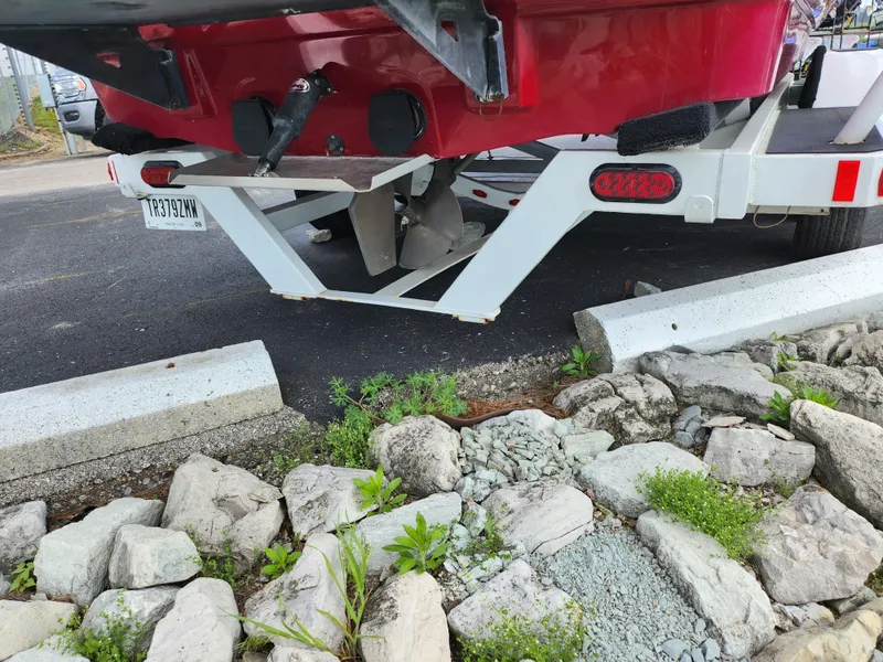 Slide: The Image of 2013 Moomba Mojo 2.5 boat trailer parked near rocks and greenery. - 3