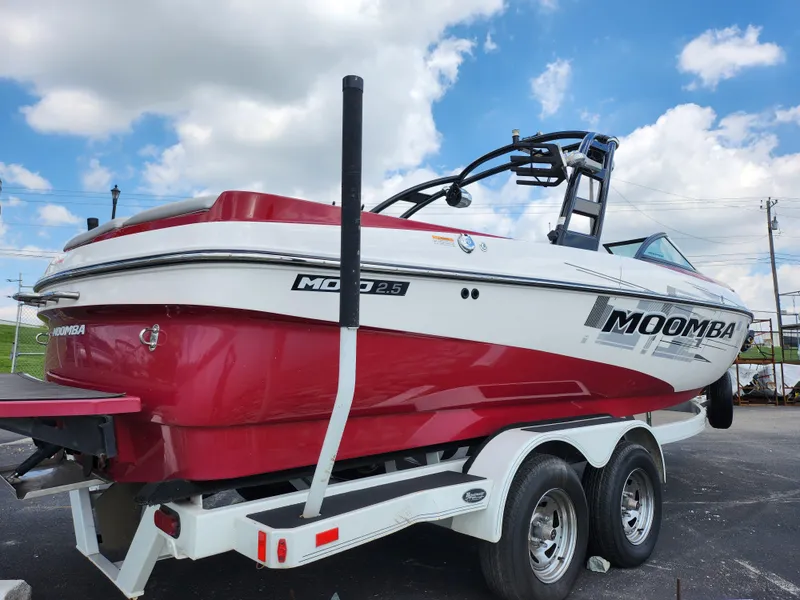 Slide: The Image of 2013 Moomba Mojo 2.5 boat on trailer, red and white design, parked outdoors. - 4