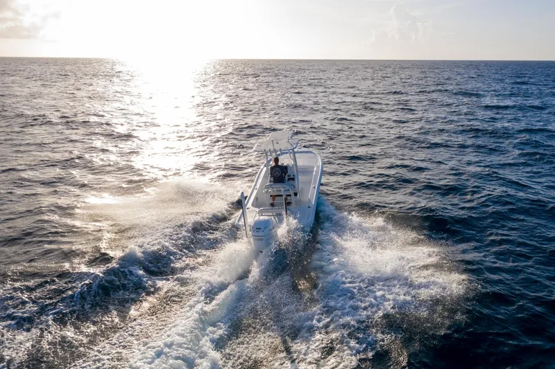 Slide: The Image of 2025 Yellowfin 24 Bay CE boat cruising on open ocean at sunset. - 7
