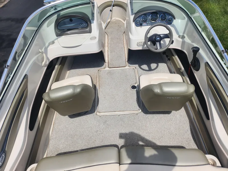 Slide: The Image of 2004 Sea Ray 200 Sport boat interior with beige seating and steering wheel. - 10