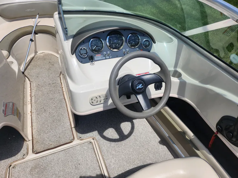 Slide: The Image of 2004 Sea Ray 200 Sport boat dashboard with steering wheel and instrument panel. - 11