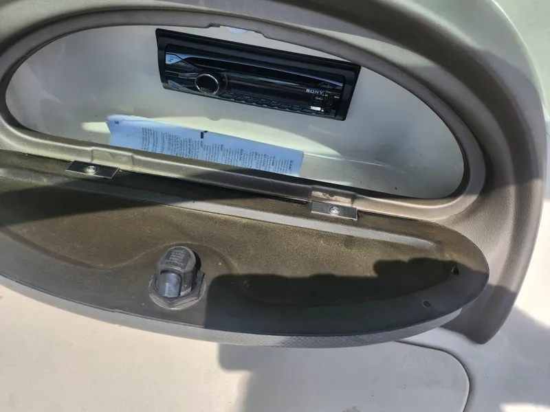 Slide: The Image of 2004 Sea Ray 200 Sport glove compartment with stereo system and manual. - 14