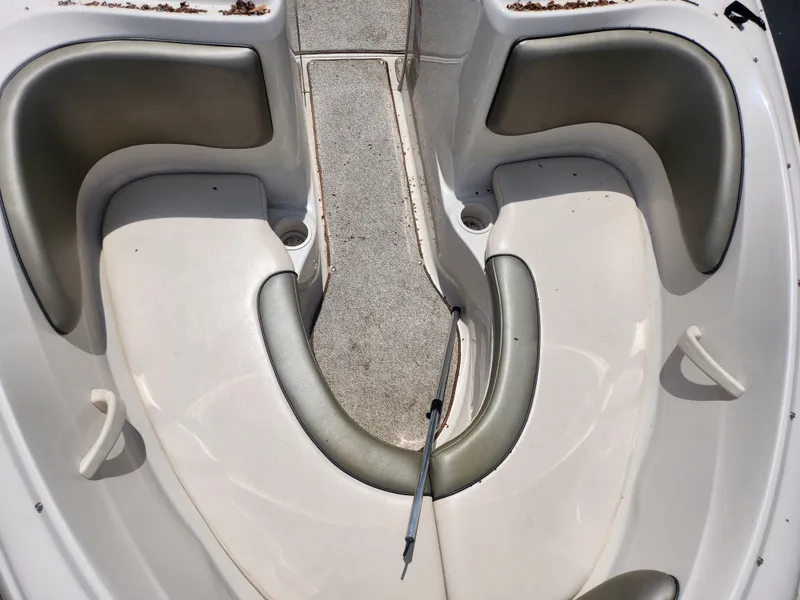 Slide: The Image of 2004 Sea Ray 200 Sport boat interior with cushioned seating and carpeted flooring. - 18