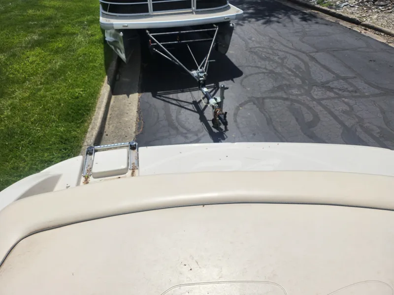 Slide: The Image of 2004 Sea Ray 200 Sport boat on trailer, parked on driveway near grass. - 24