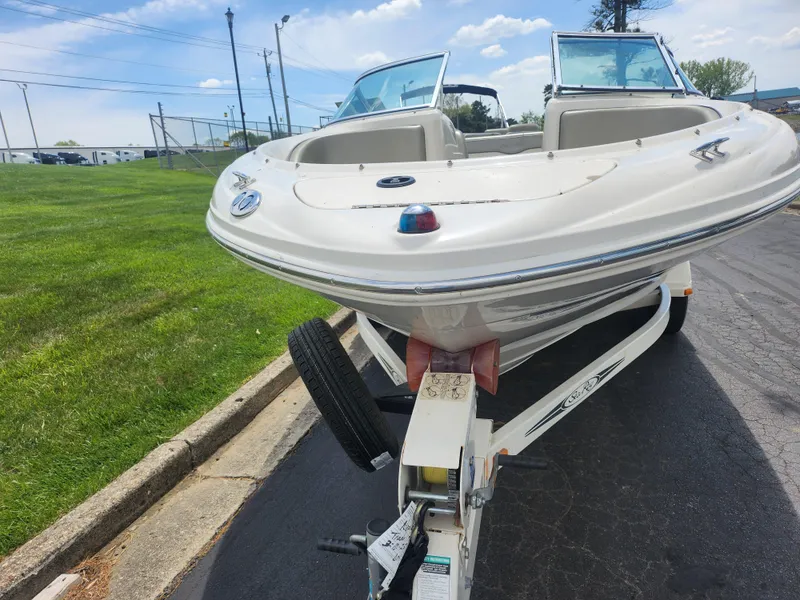 Slide: The Image of 2004 Sea Ray 200 Sport boat on trailer, parked on a paved road. - 5