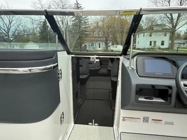 Slide: The Image of 2023 Regal LS6 boat interior with modern dashboard and open cabin view. - 16