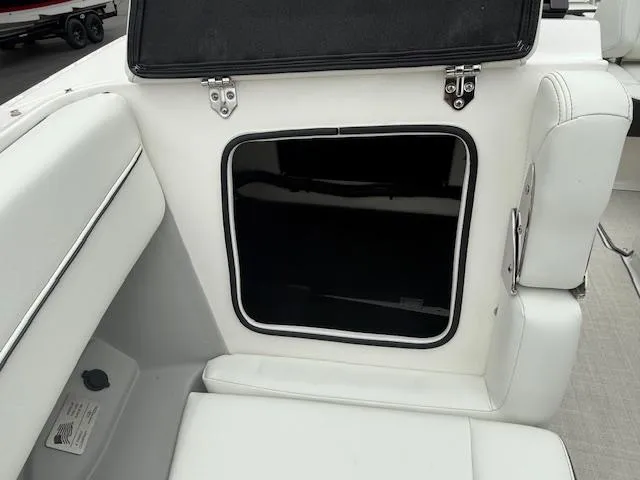 Slide: The Image of 2023 Regal LS6 boat interior with white seating and storage compartment. - 18
