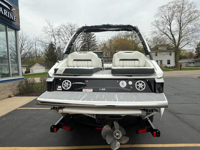 Slide: The Image of 2023 Regal LS6 boat with dual seats and sleek design, parked outdoors. - 2