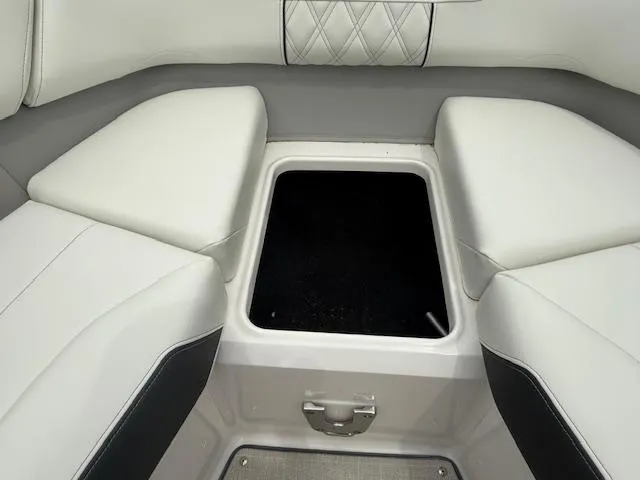 Slide: The Image of 2023 Regal LS6 boat interior with white cushioned seating and storage compartment. - 21