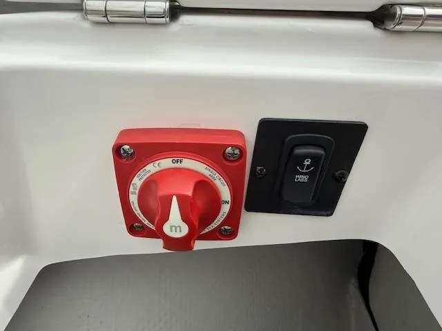 Slide: The Image of Red power switch and black anchor button on 2023 Regal LS6 boat. - 23