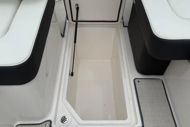 Slide: The Image of 2023 Regal LS6 boat storage compartment with cushioned seating and drain. - 26