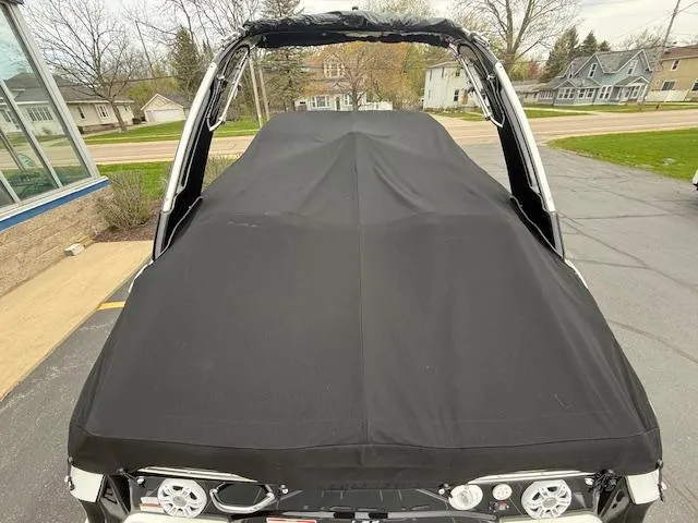 Slide: The Image of 2023 Regal LS6 boat with black cover, parked outdoors. - 42