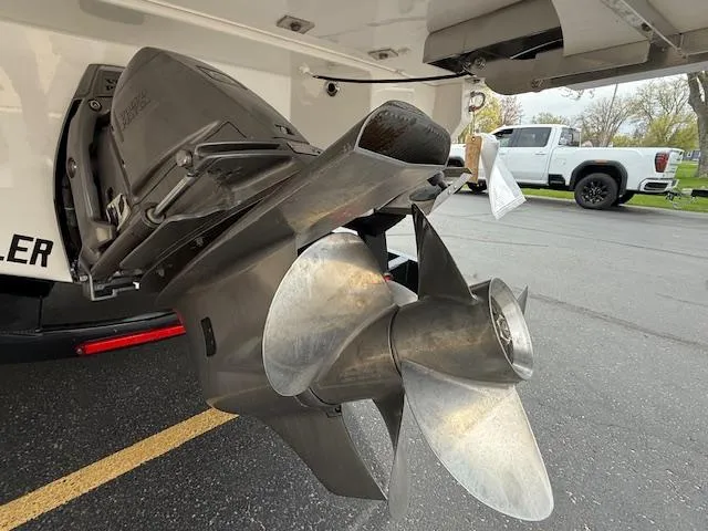 Slide: The Image of 2023 Regal LS6 boat propeller, close-up view, parked on asphalt with a truck in the background. - 44