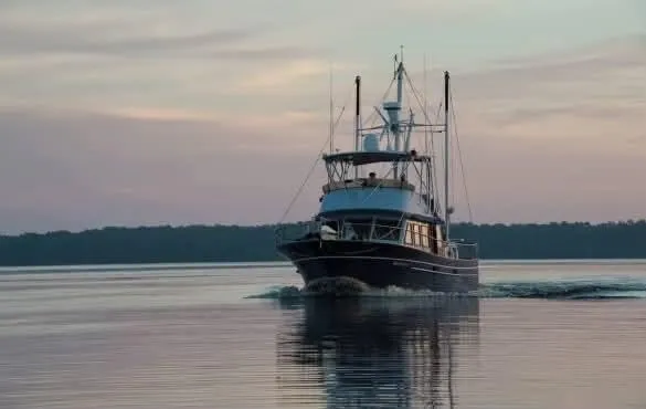 Slide: The Image of 1981 Albin 45 Command Bridge yacht cruising on calm waters at sunset. - 10