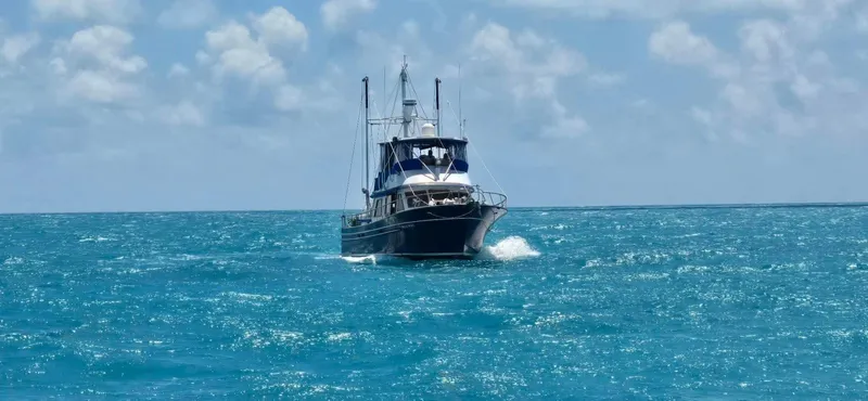 Slide: The Image of 1981 Albin 45 Command Bridge cruising on open sea under a partly cloudy sky. - 13