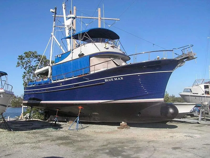 Slide: The Image of 1981 Albin 45 Command Bridge boat, "Blue Max," on land under clear blue sky. - 20