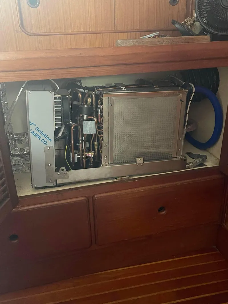 Slide: The Image of 1981 Albin 45 Command Bridge engine compartment with visible machinery and wooden cabinetry. - 27