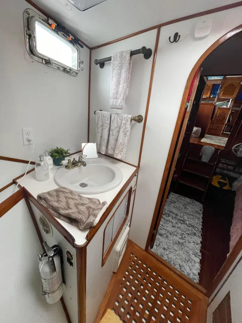 Slide: The Image of 1981 Albin 45 Command Bridge bathroom with sink, towels, and wooden accents. - 32