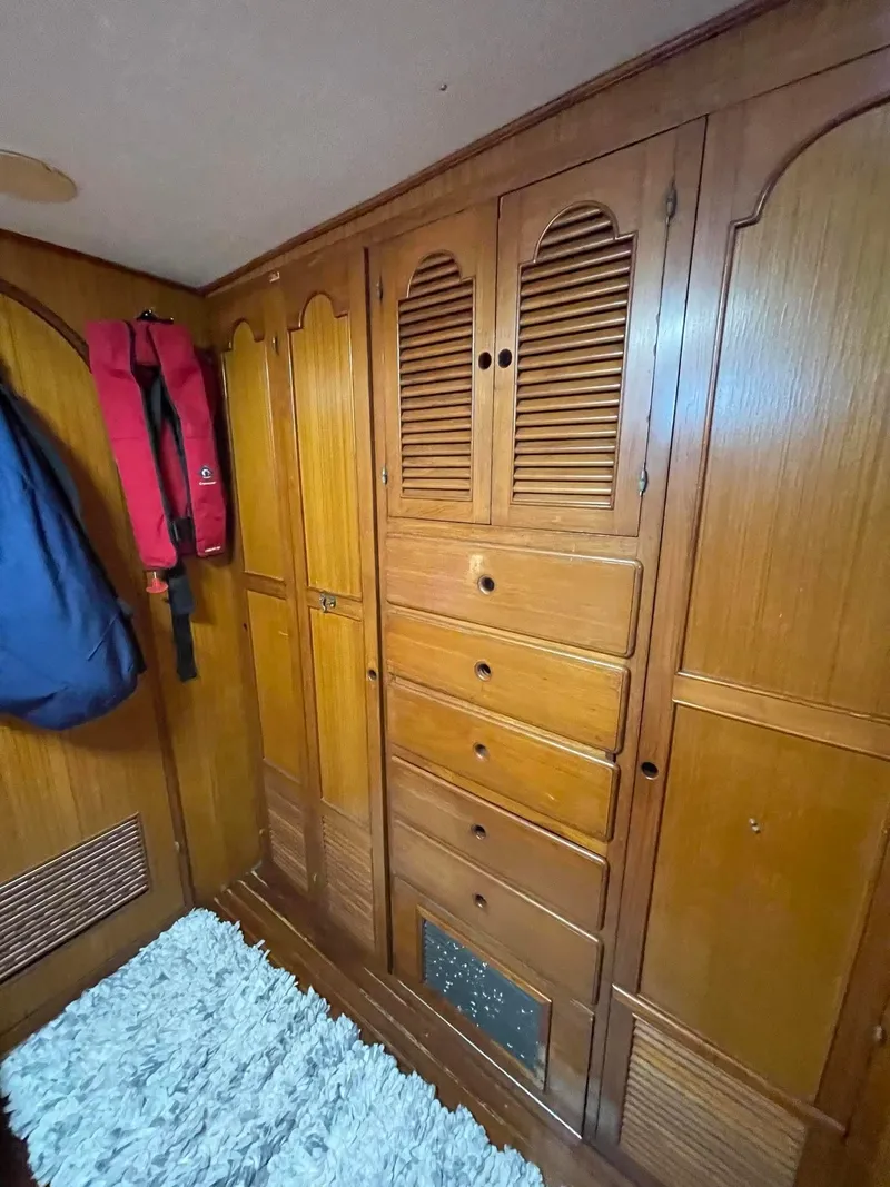 Slide: The Image of 1981 Albin 45 Command Bridge interior with wooden cabinetry and hanging life jackets. - 33