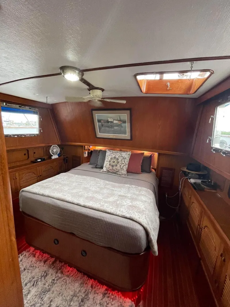 Slide: The Image of 1981 Albin 45 Command Bridge bedroom with wood paneling and cozy bed. - 36