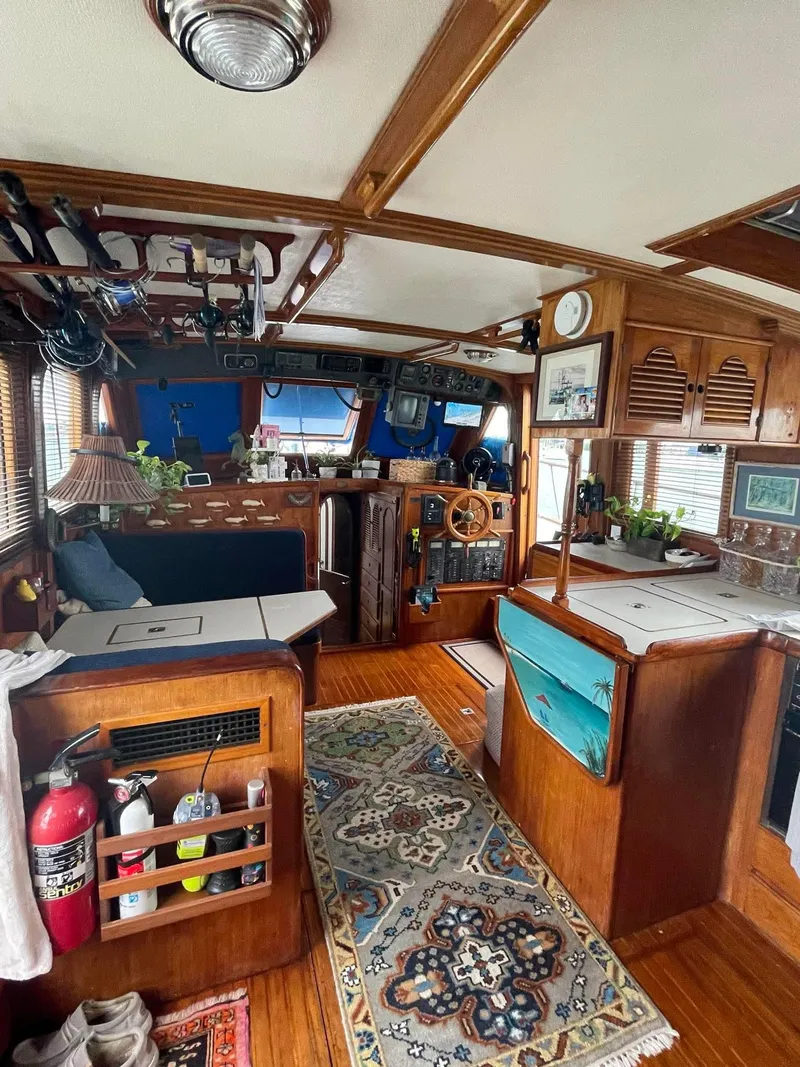 Slide: The Image of 1981 Albin 45 Command Bridge interior with wood finish, cozy seating, and nautical decor. - 39
