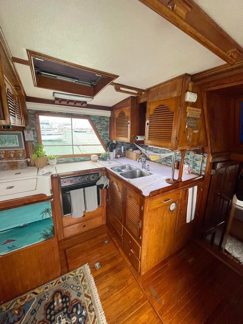 Slide: The Image of 1981 Albin 45 Command Bridge interior with wooden cabinetry and kitchen amenities. - 4