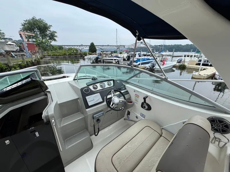 Slide: The Image of 2015 Sea Ray 280 Sundancer boat cockpit with marina view in the background. - 32