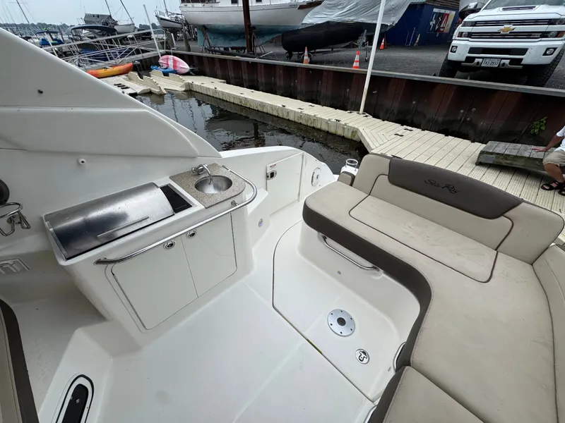 Slide: The Image of 2015 Sea Ray 280 Sundancer boat interior with seating and kitchenette at marina. - 33