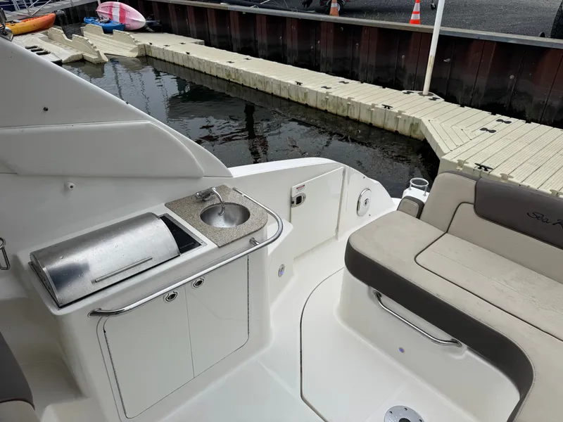 Slide: The Image of 2015 Sea Ray 280 Sundancer boat interior with sink and seating at dock. - 34
