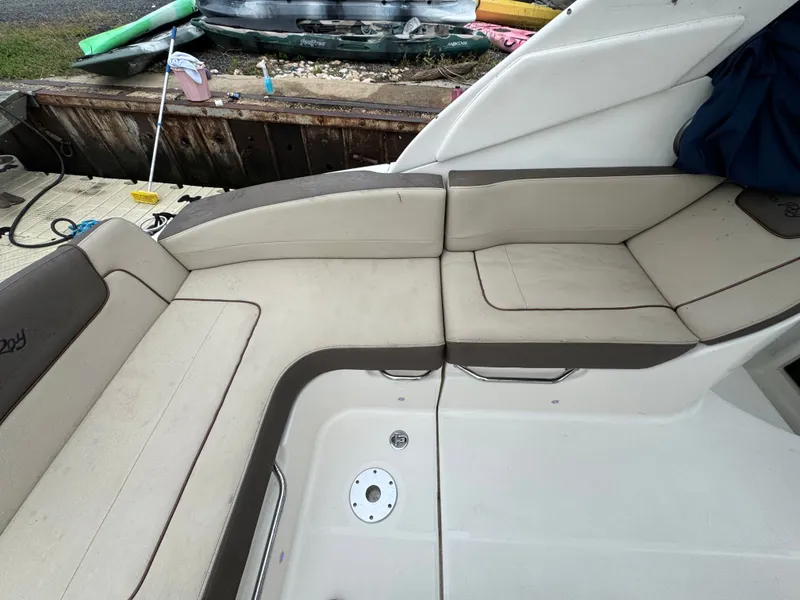 Slide: The Image of Interior seating of 2015 Sea Ray 280 Sundancer boat, featuring beige and brown cushions. - 35