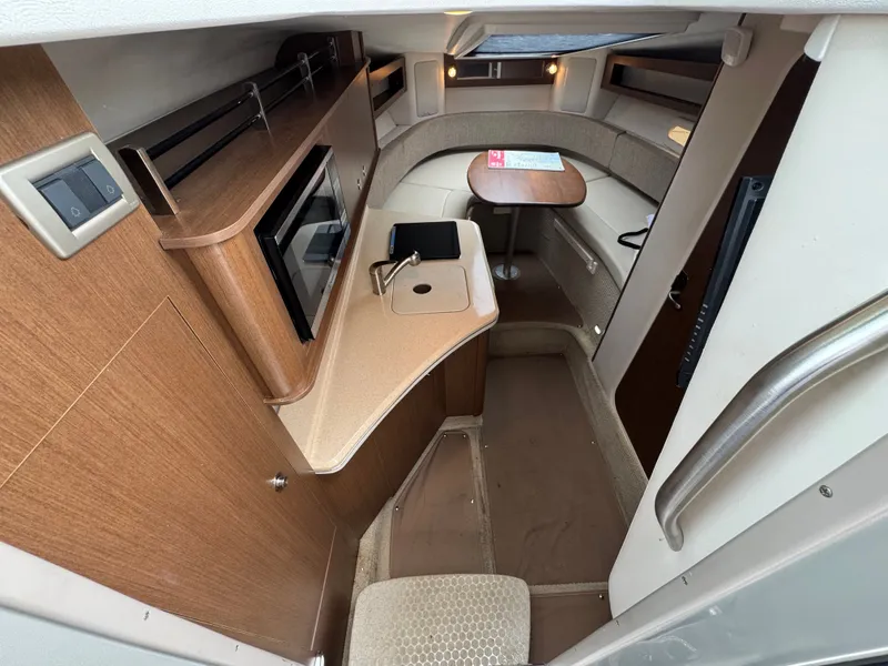 Slide: The Image of 2015 Sea Ray 280 Sundancer cabin interior with kitchenette and seating area. - 43