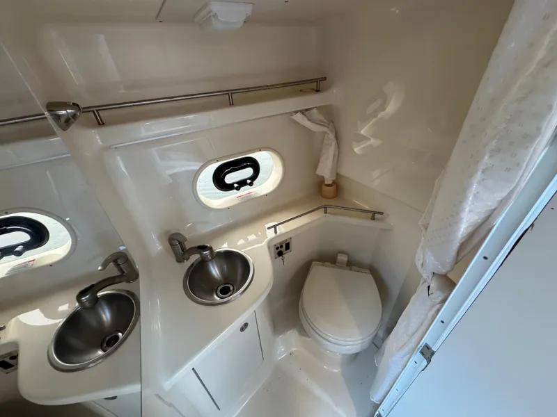 Slide: The Image of 2015 Sea Ray 280 Sundancer bathroom with sink, toilet, and porthole window. - 46