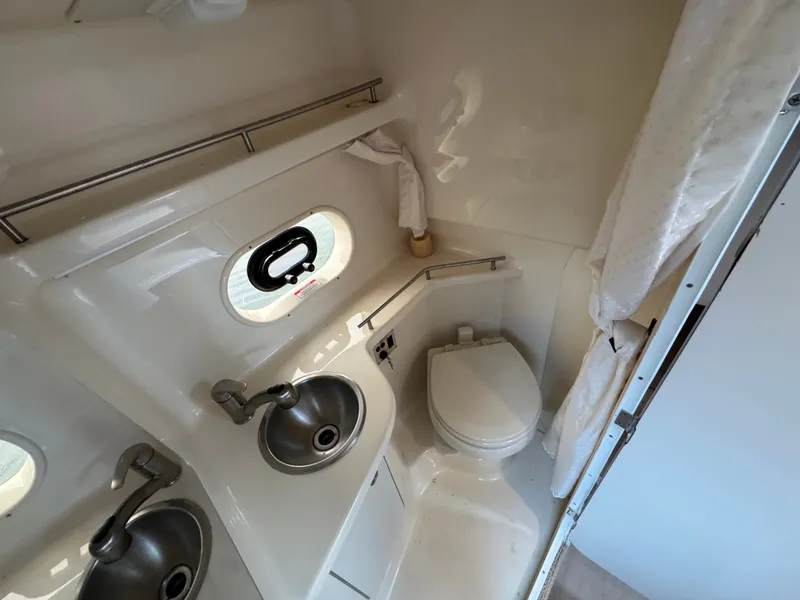 Slide: The Image of 2015 Sea Ray 280 Sundancer bathroom with sink, toilet, and porthole window. - 47