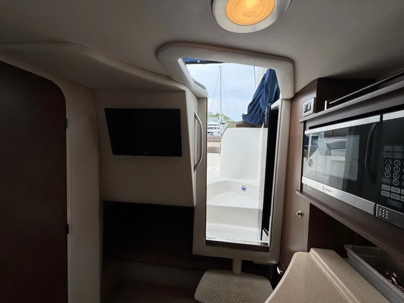 Slide: The Image of Interior of 2015 Sea Ray 280 Sundancer with microwave and TV, open cabin door. - 48