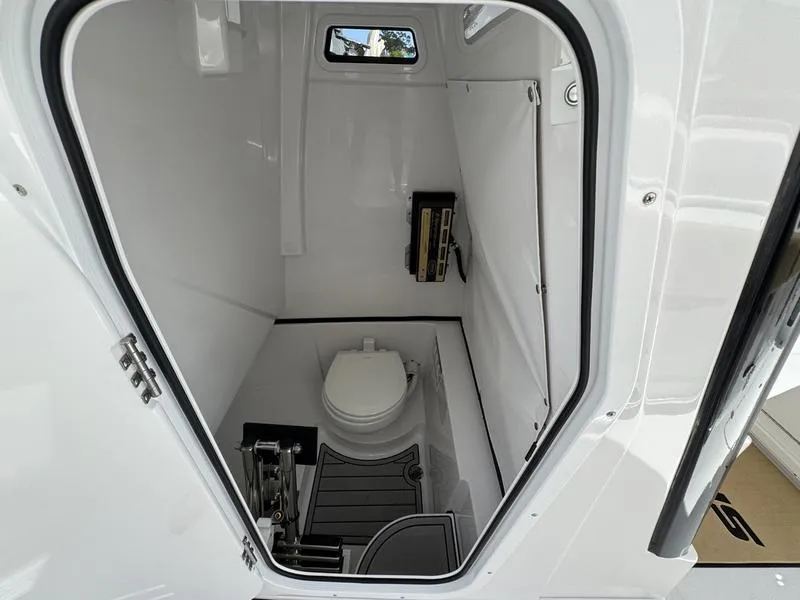 Slide: The Image of 2025 Sportsman Heritage 261 boat interior with compact marine toilet and storage. - 18